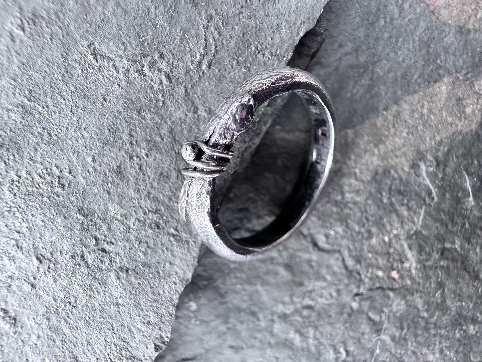 Half round ring with a knot detail scars on one side it is oxidated and has a raw surface on one 50 % side